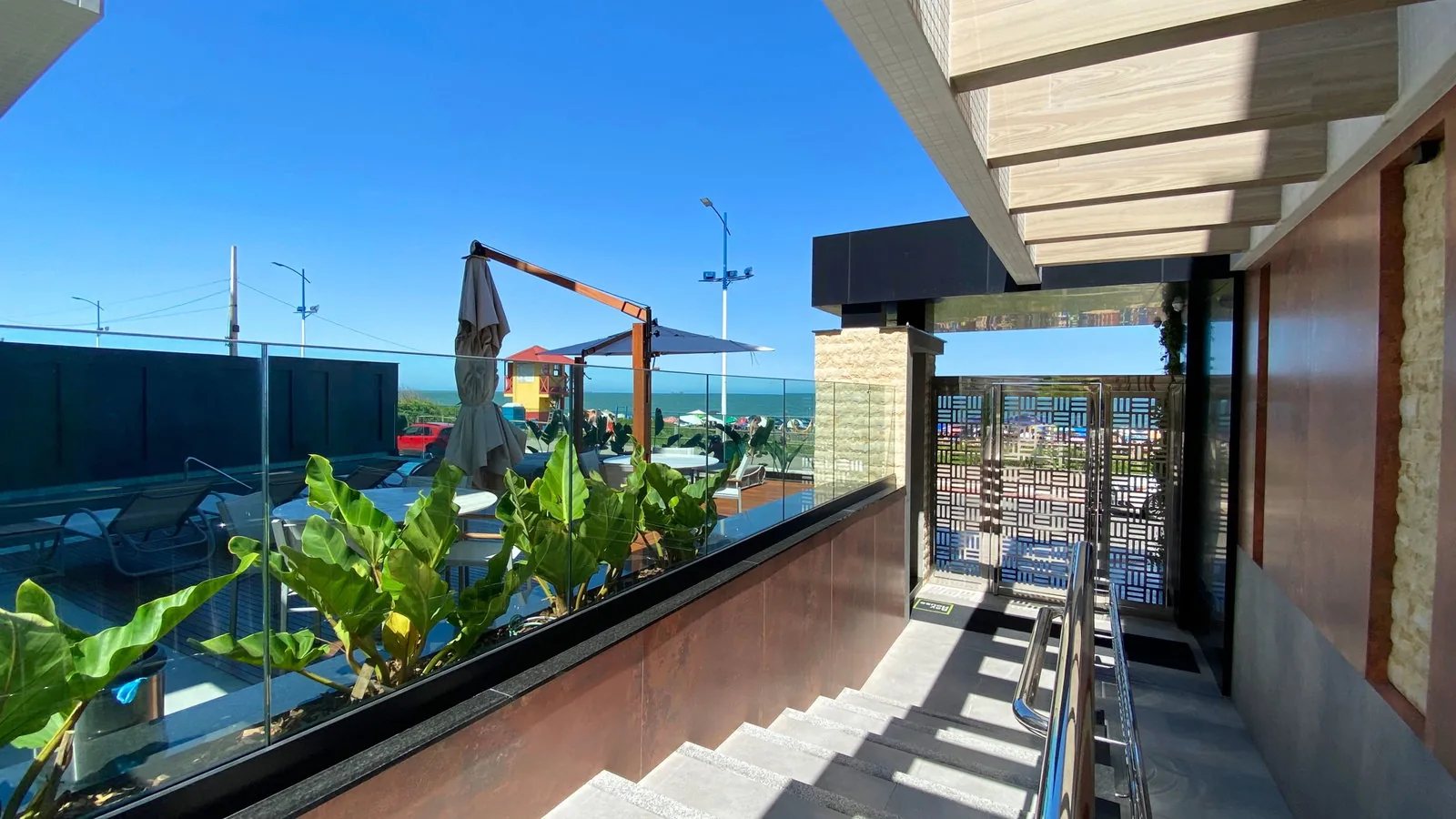 Bay House · terraço com pergolado e paisagismo