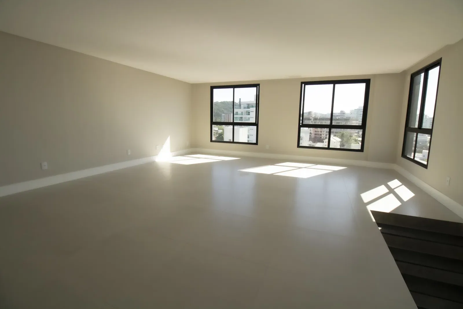 Living do apartamento duplex do Brava 22, com janelas de canto