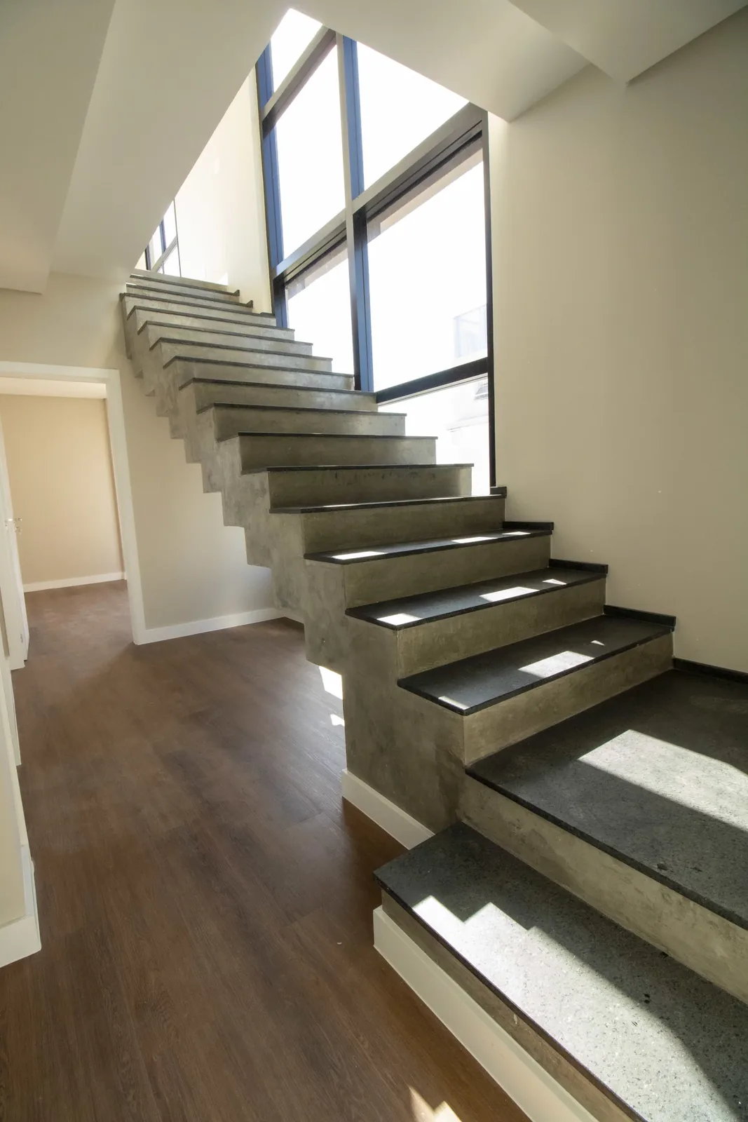Escada interna do duplex do Brava 22, em piso de madeira