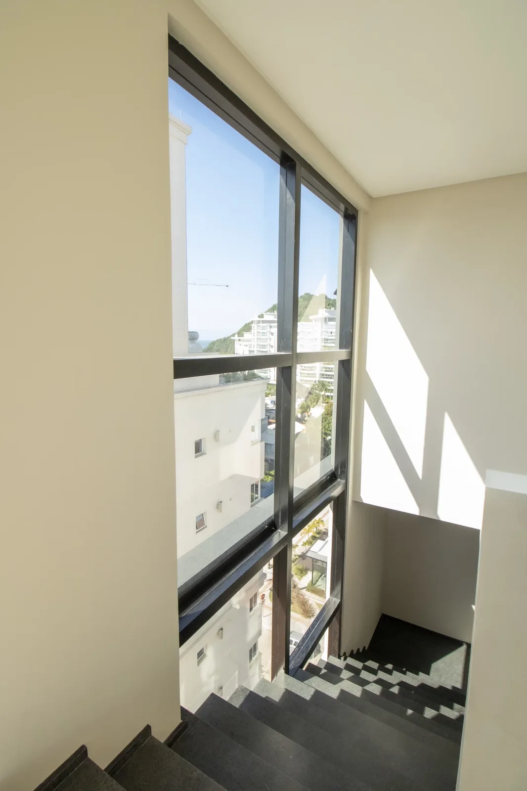 Escada do duplex do Brava 22, iluminada por janela alta