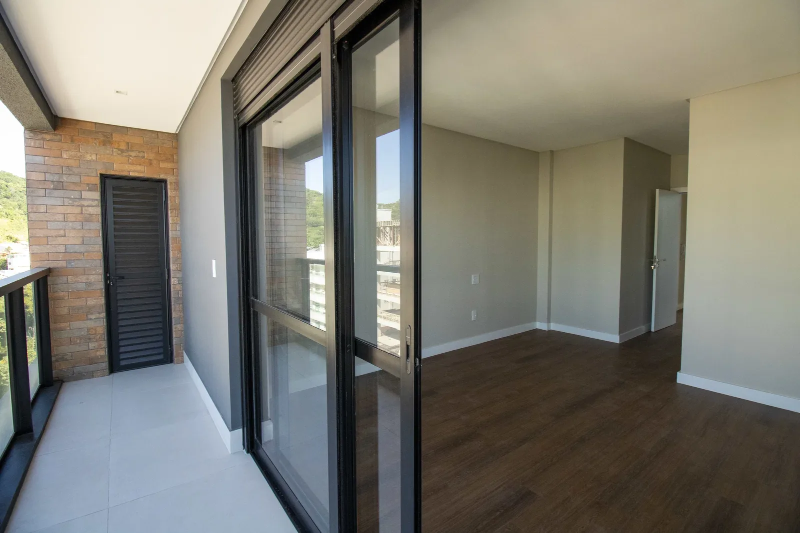 Sacada do duplex do Brava 22, com parede em tijolo aparente