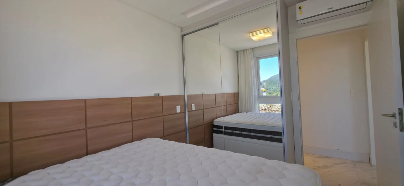Suíte master do apartamento do Brava Prime, com cabeceira em madeira