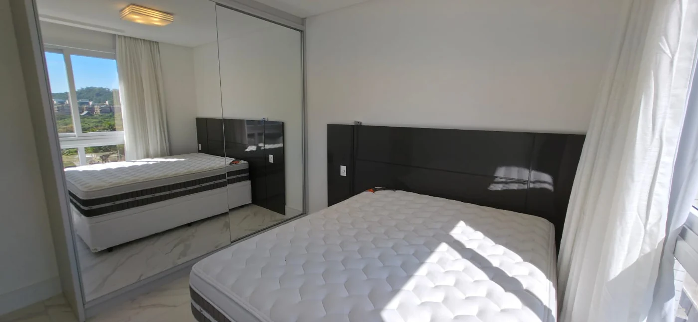 Suíte do apartamento do Brava Prime, com parede espelhada