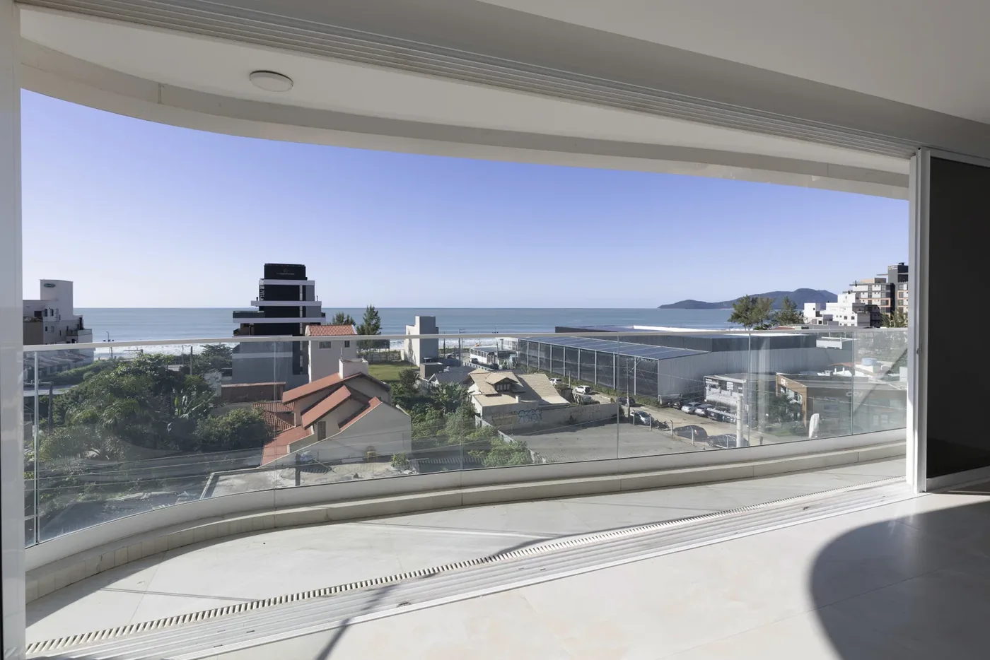 Apartamento 501 do Le Blanc, na Praia Brava: living com painel de vidro curvo e vista panorâmica para o mar