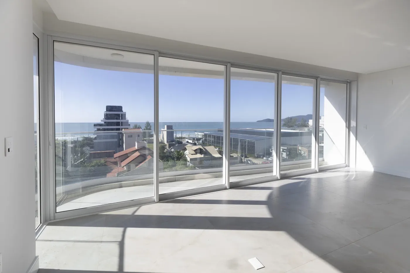 Sacada envidraçada do apartamento 501 do Le Blanc, voltada para o mar