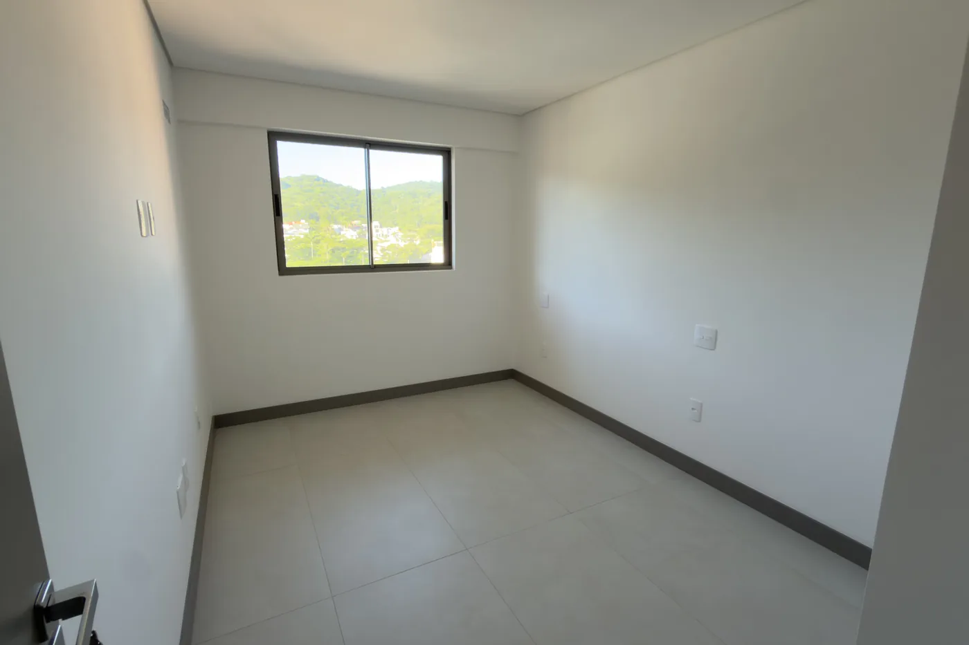 Dormitório do apartamento do Soul Brava Club, com vista para o morro